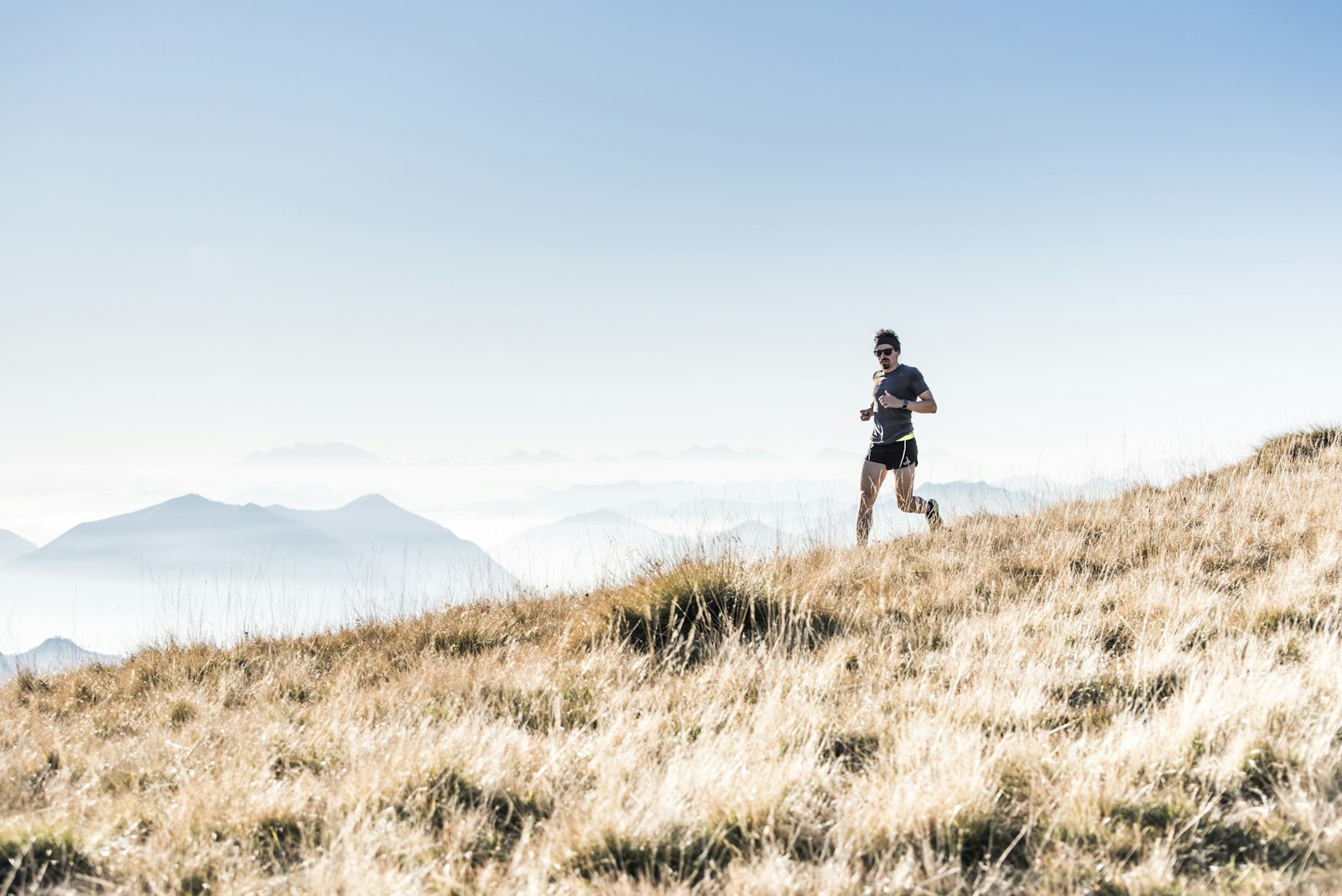 Runner climbing a mountain trail at sunrise, illustrating how to reverse mitochondrial dysfunction with training