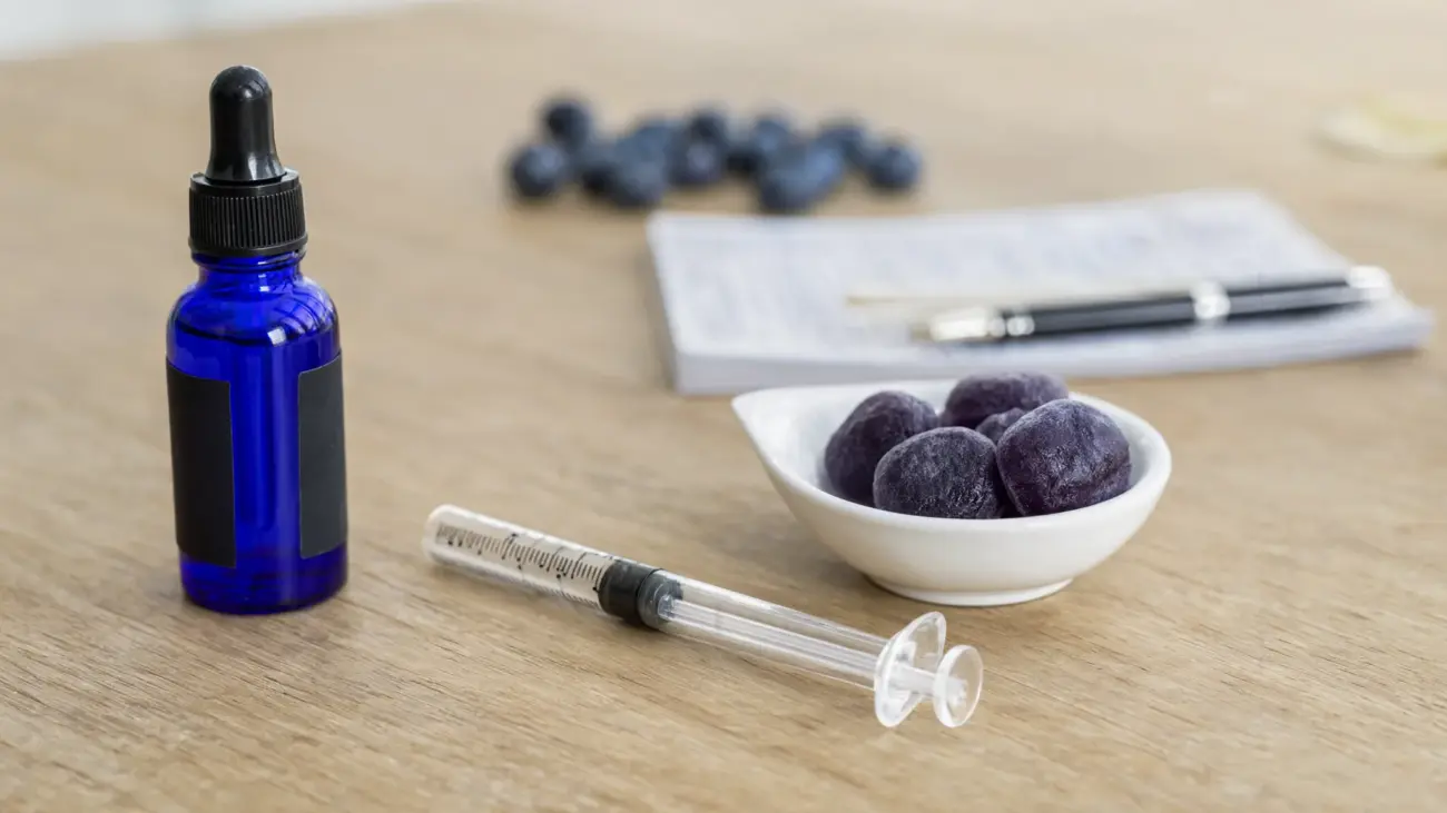 Biotech Labs methylene blue review: a cobalt dropper bottle, an oral measuring syringe and purple methylene blue gummies on a desk