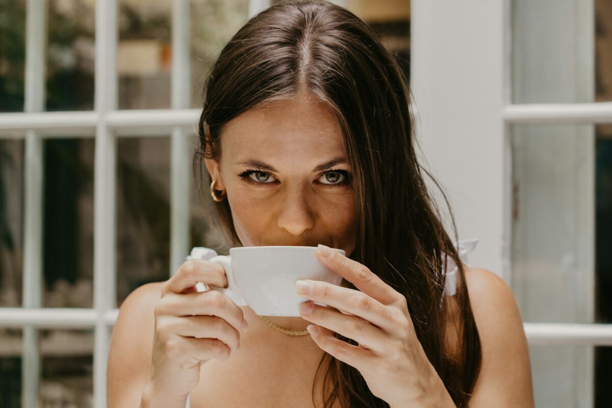 Best supplements for menopause brain fog guide: a woman drinking from a cup by a window